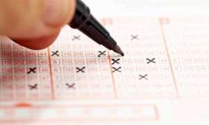 A man filling out a lottery ticket