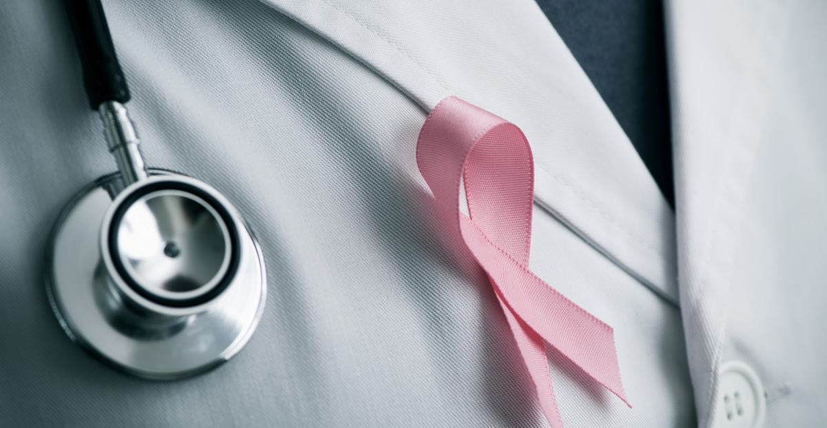 A doctor with pink ribbon signifying breast cancer awareness month