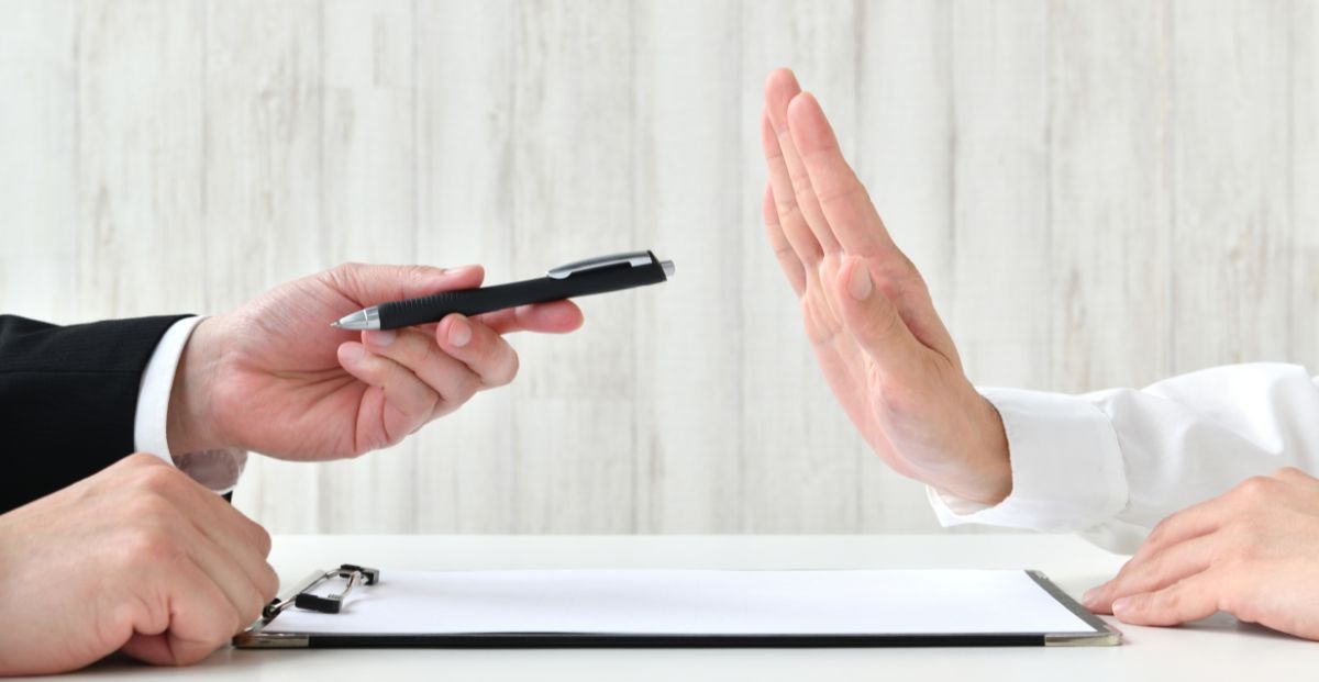 a person holding off another who is looking for a signature